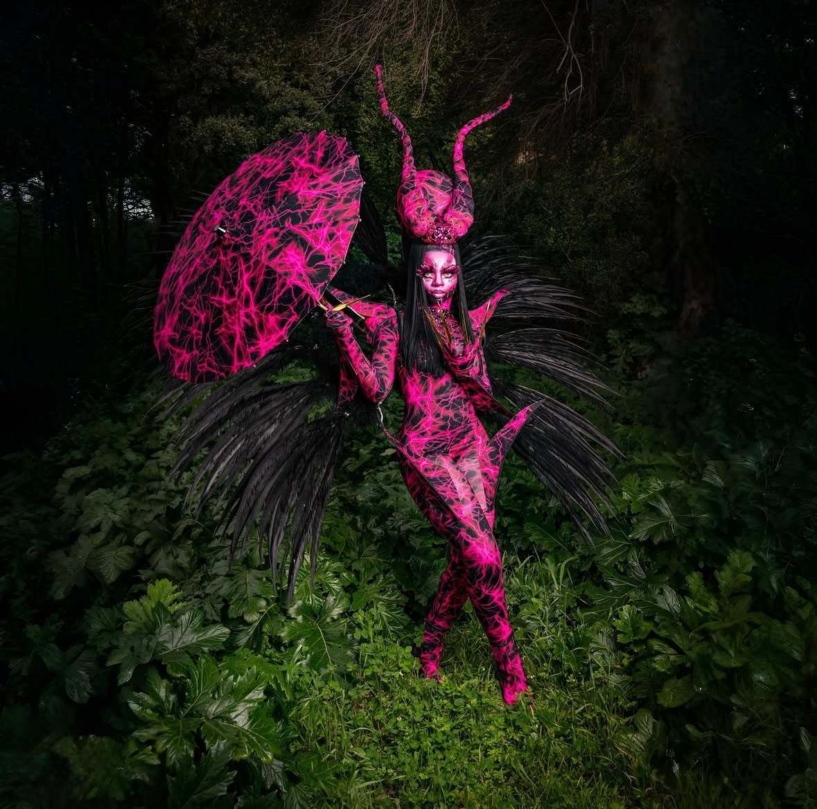 Créature rose fluorescent et noire, photographiée de nuit dans la végétation