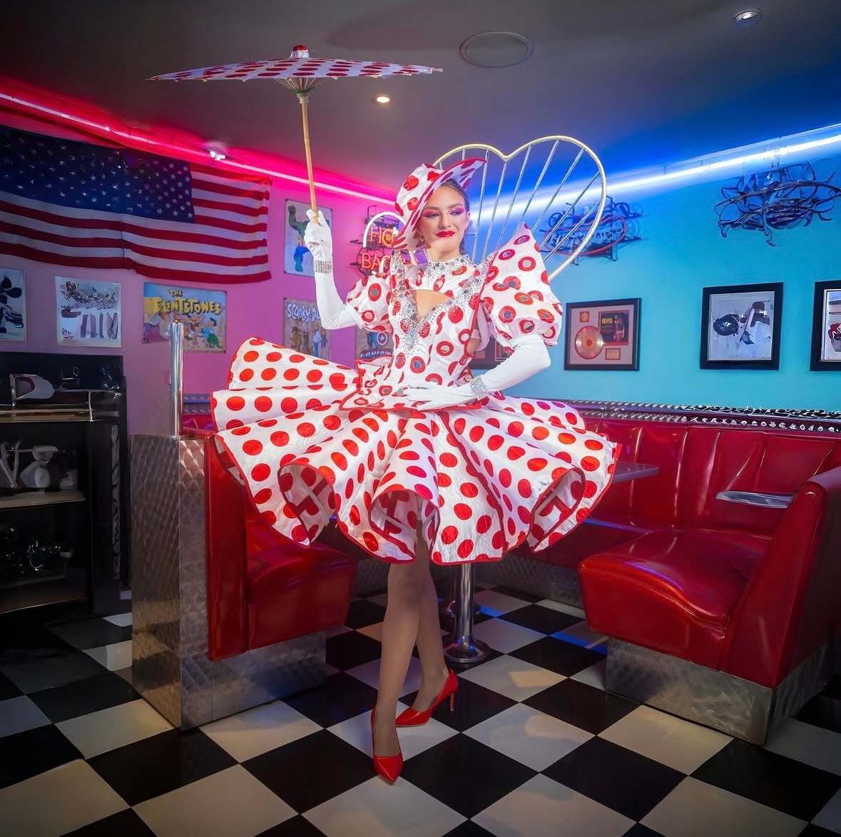Artiste en robe à pois rouge et blanche avec une coiffe en forme de cœur